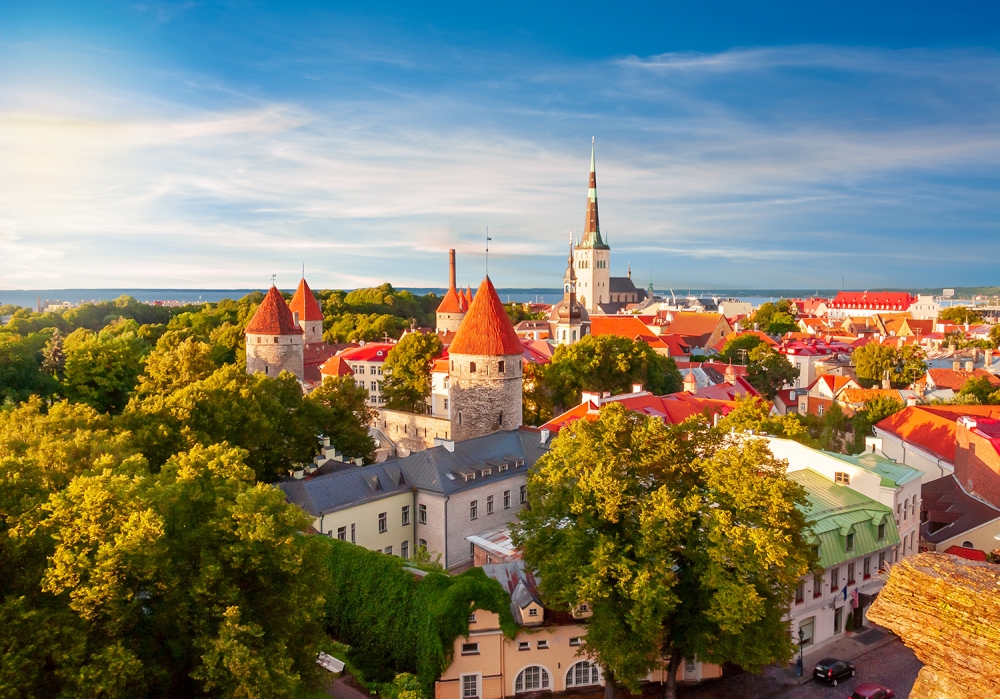 Scenic Tallinn summer cityscape with Saint Olav's church and old town walls and towers at sunset, Estonia