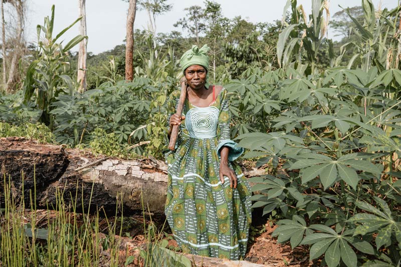 Woman sitting on a log in a forest in Cameroon