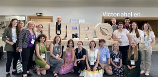 EFI staff posing for a group photo in front of the wooden sign IUFRO