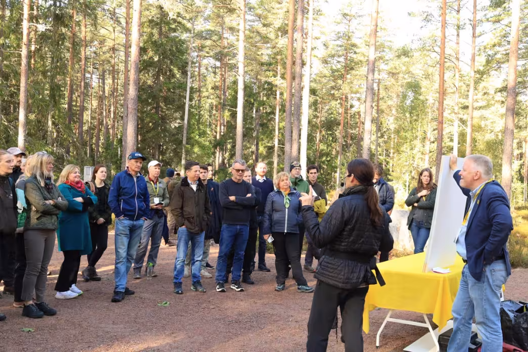 field trip participants listening to a presentation in the forest
